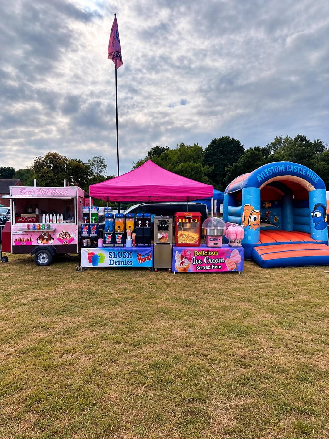 The full Angry Donut setup: donut trailer, slush machines, ice cream, popcorn and candy floss under a pink gazebo